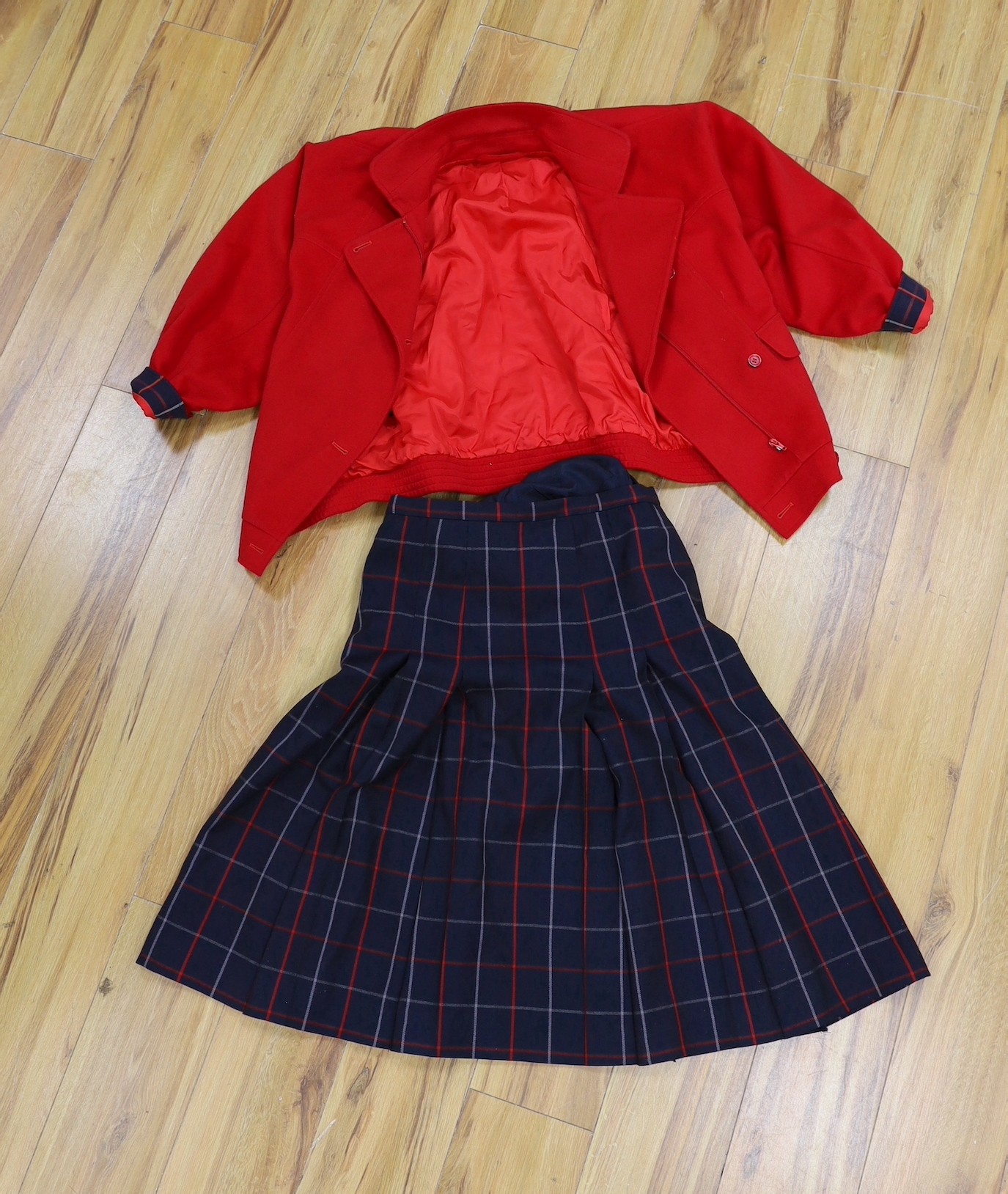 Two vintage Burberry items of clothing: a pleated skirt and a red Harrington jacket